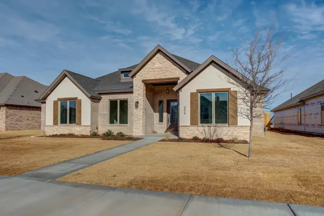 a front view of a house with yard and parking