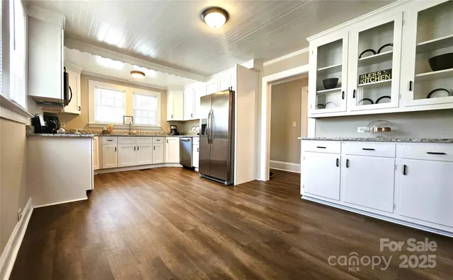 a kitchen with cabinets wooden floor and a window