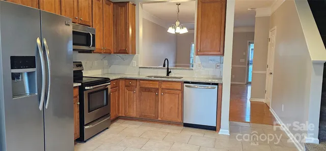 a kitchen with stainless steel appliances granite countertop a refrigerator and a sink