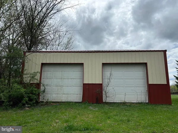 a backyard of a house with garage and entertaining space