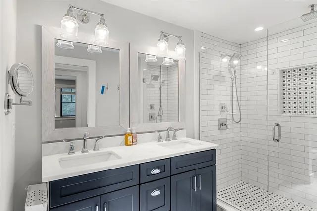 a bathroom with a double vanity sink mirror and shower