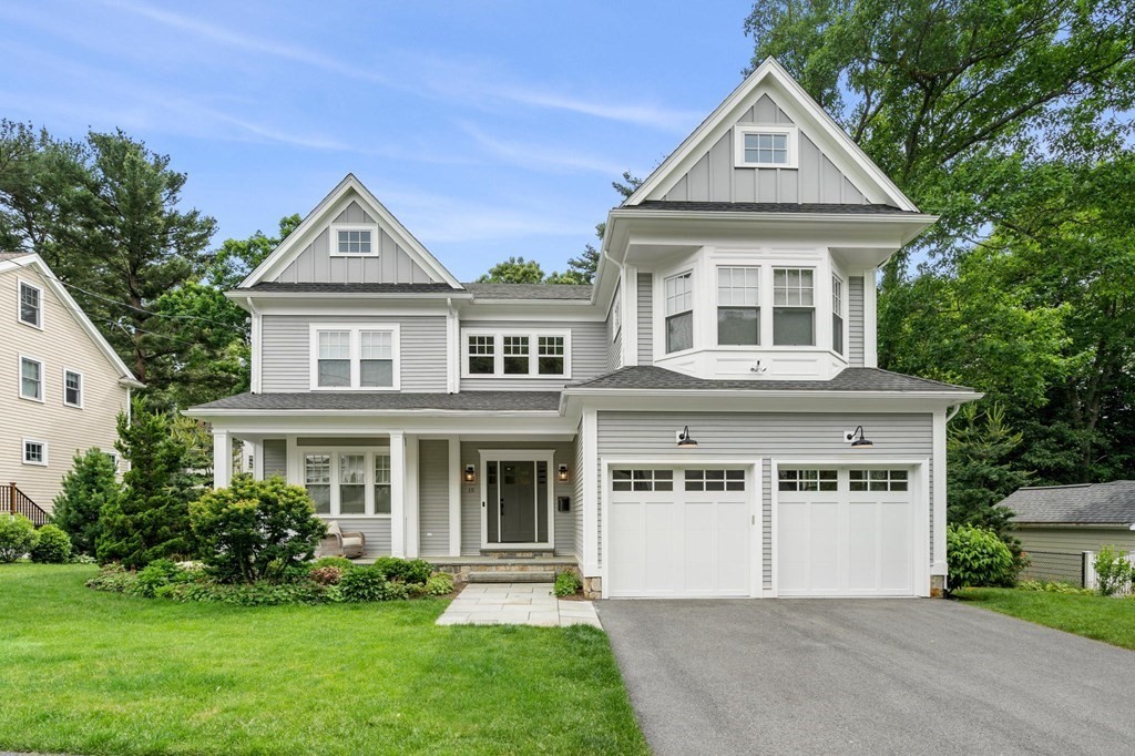 a front view of a house with a yard and trees
