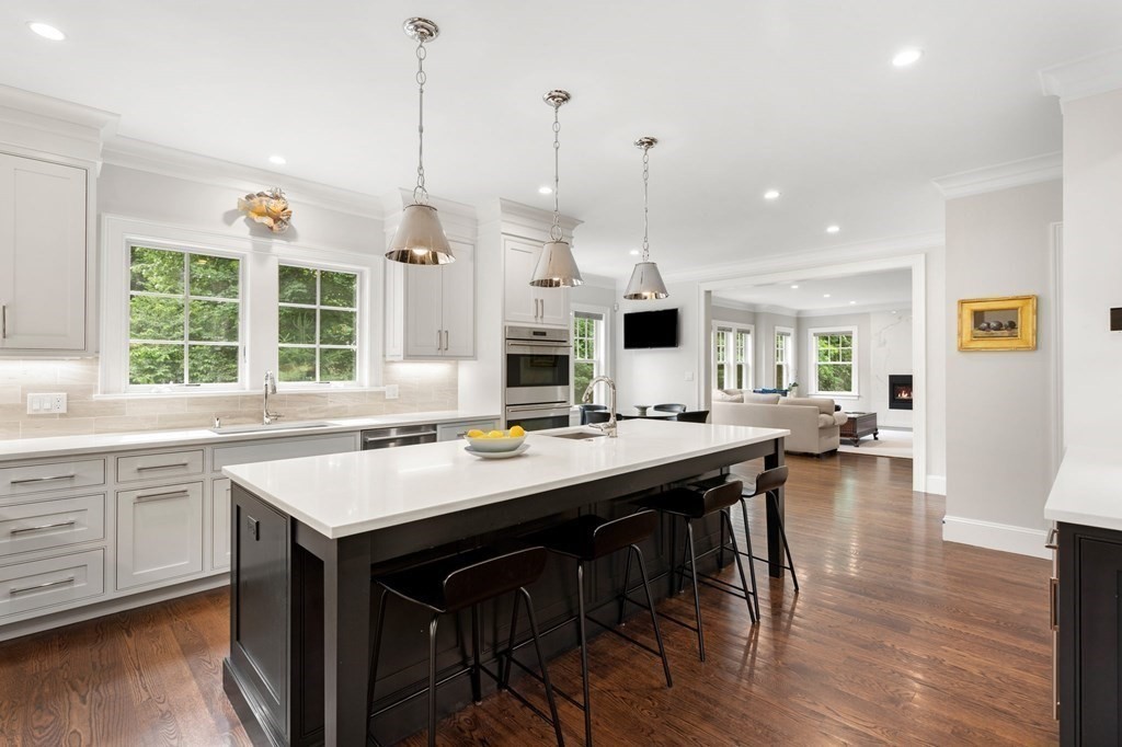 15 Parker Road Needham, MA 02494 - Photo 4 of 41 a kitchen with stainless steel appliances granite countertop a stove a sink dishwasher and a dining table with wooden floor