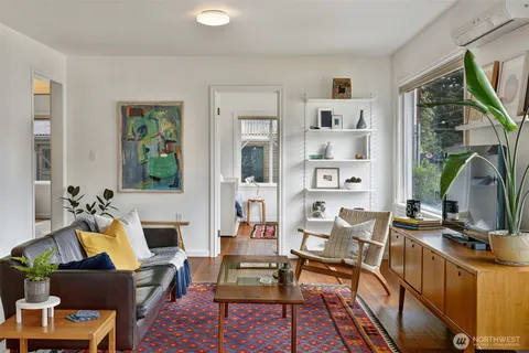 a living room with furniture a flat screen tv and a floor to ceiling window