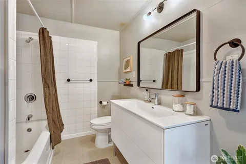 a bathroom with a sink a toilet and a large mirror