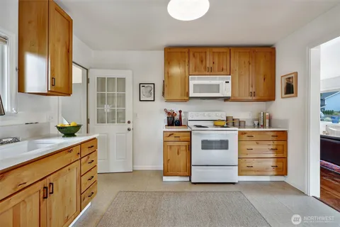 a kitchen with stainless steel appliances white cabinets and a stove top oven