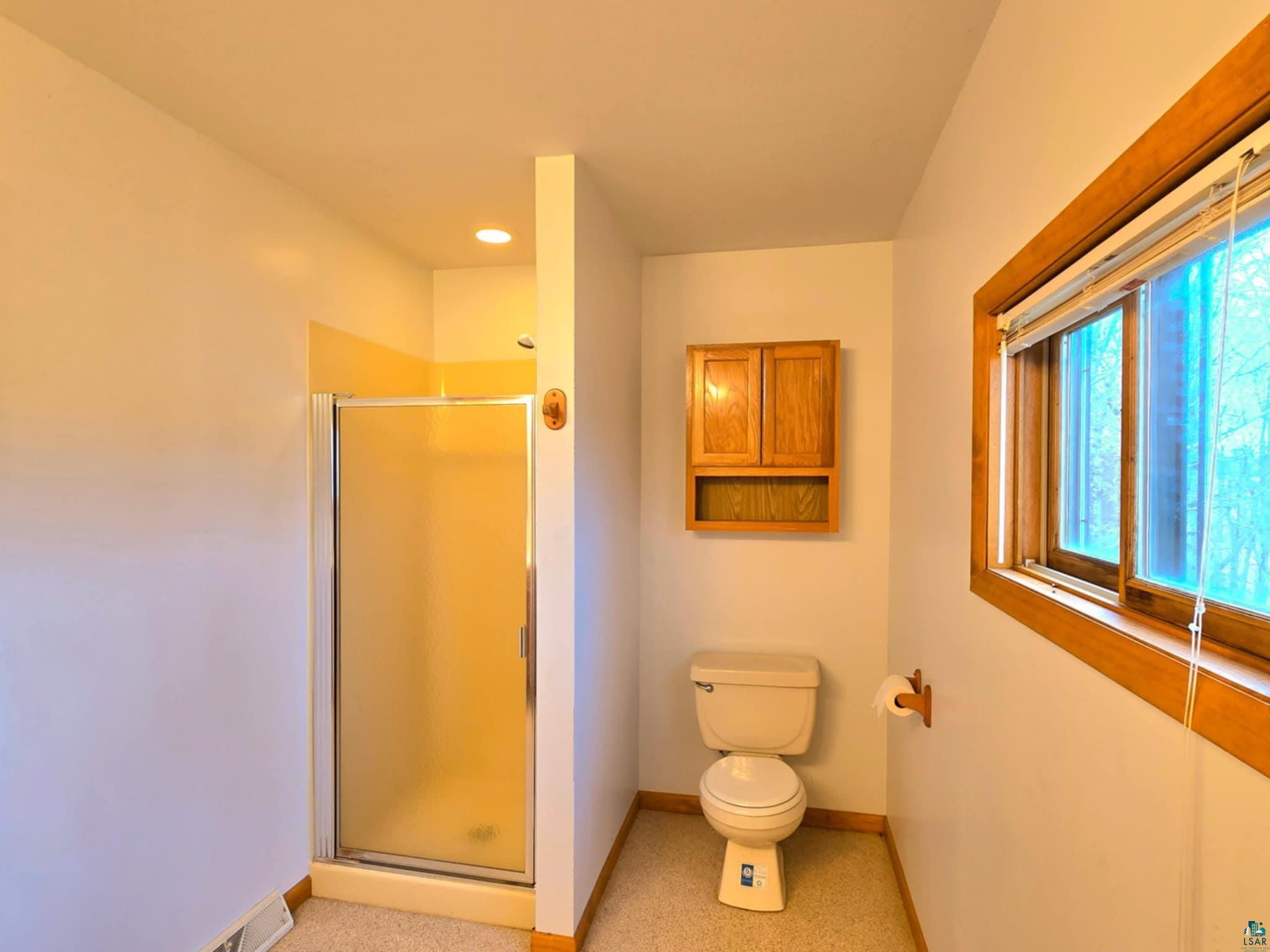 66282 County Rd C Marengo, WI 54855 - Photo 14 of 31 Bathroom with toilet, a wealth of natural light, and a shower with shower door