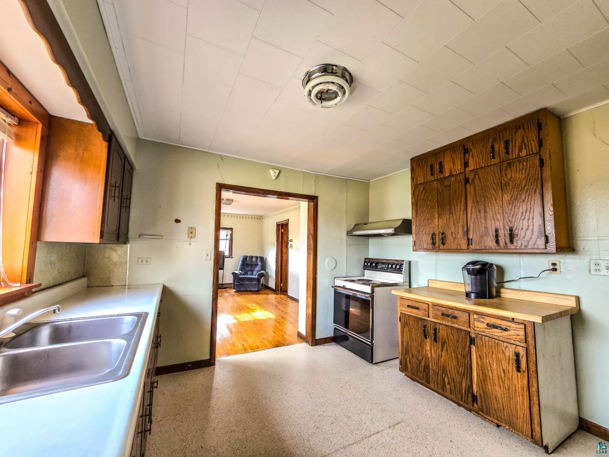 66282 County Rd C Marengo, WI 54855 - Photo 7 of 31 Kitchen with electric range, sink, and wall chimney exhaust hood
