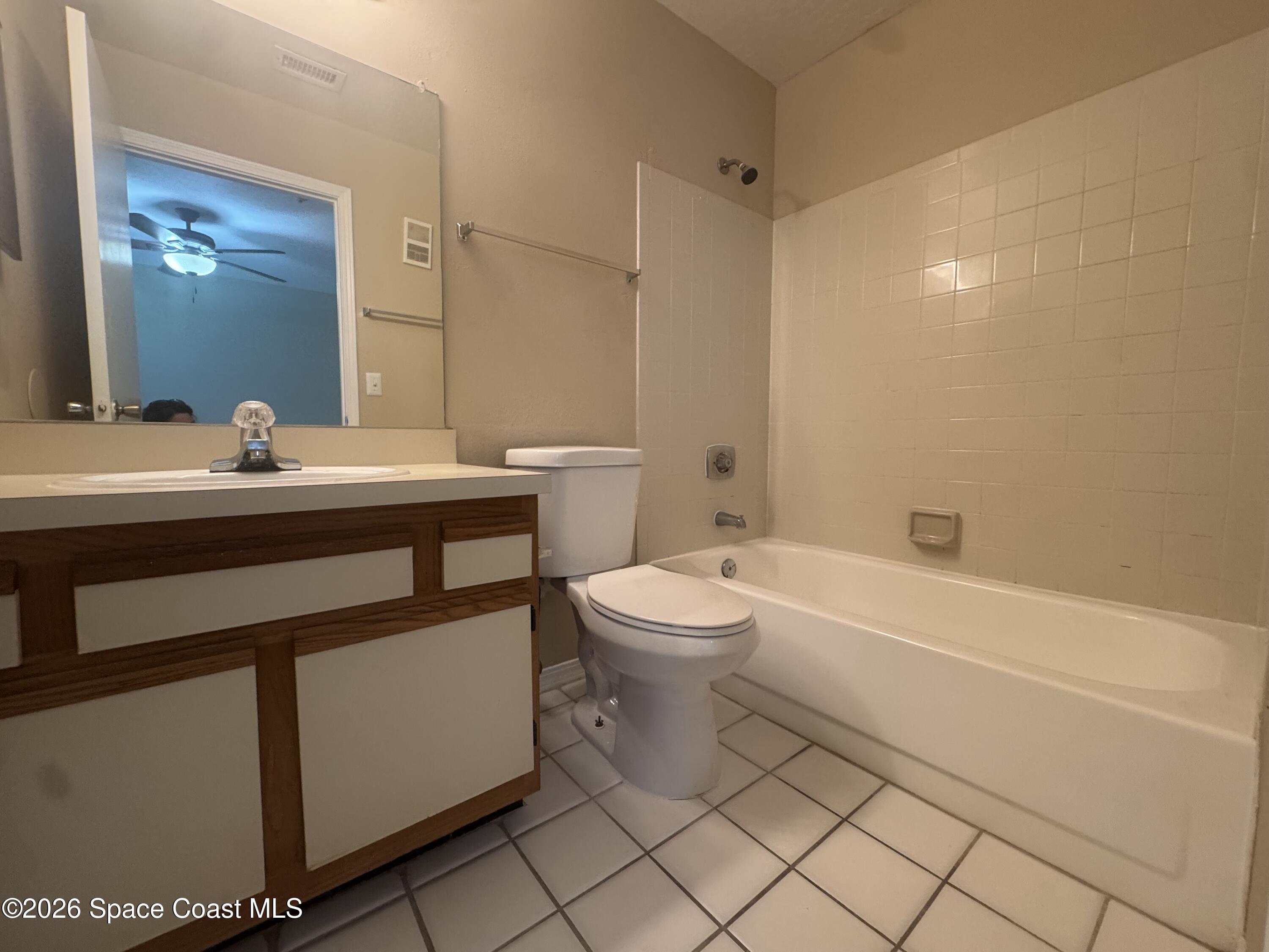 7667 North Wickham Road, Unit 1107 Melbourne, FL 32940 - Photo 9 of 19 a bathroom with a sink a toilet and a mirror