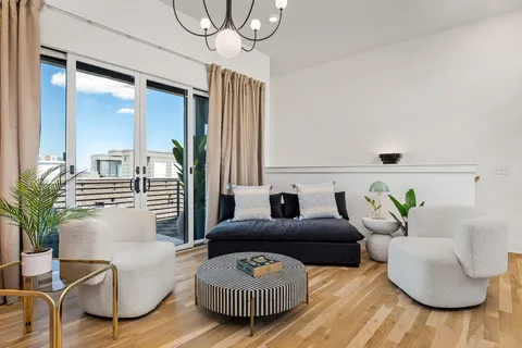 a living room with furniture a chandelier and a large mirror