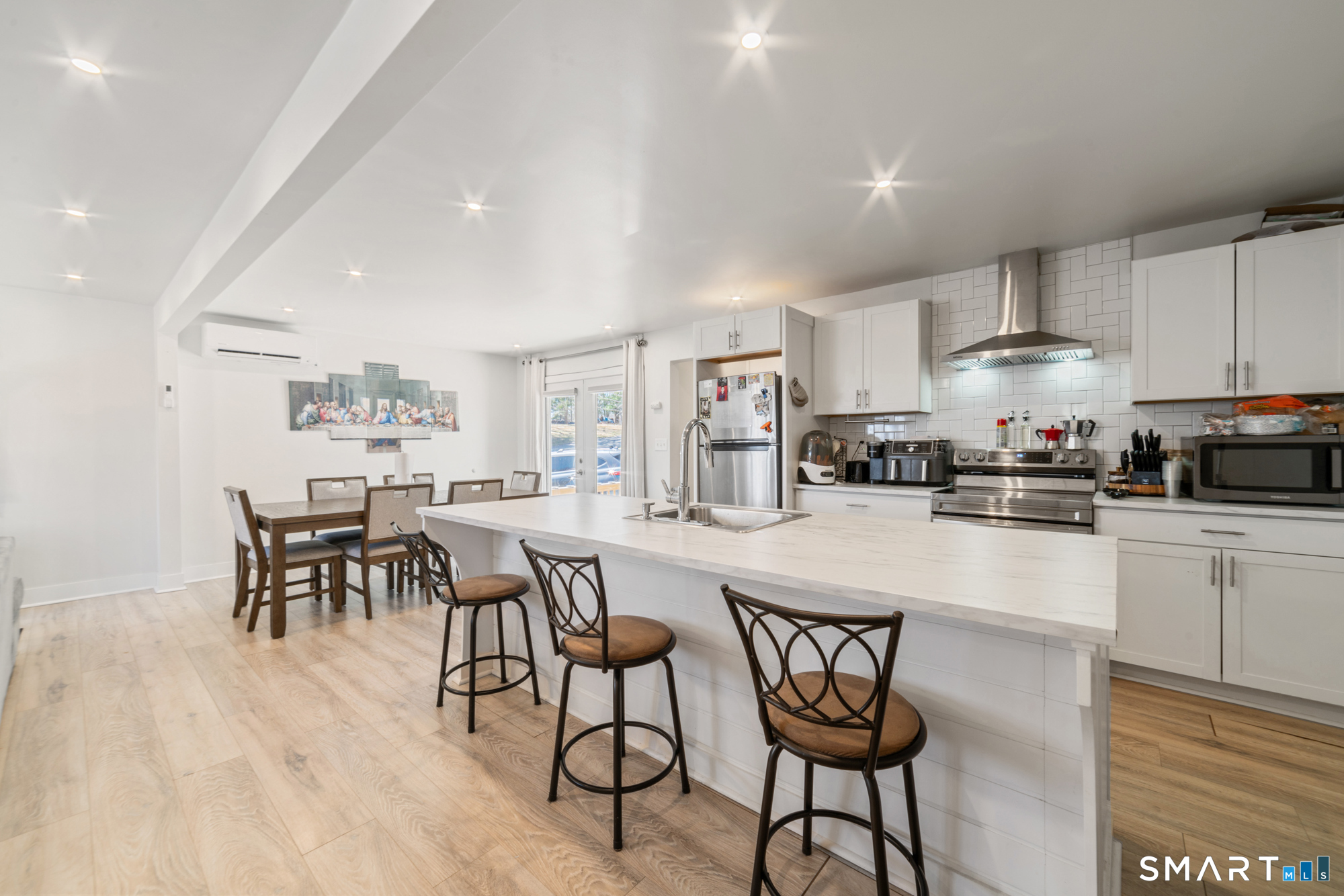 327 Lakeside Boulevard West Waterbury, CT 06708 - Photo 2 of 29 a kitchen with stainless steel appliances a dining table chairs stove and white cabinets
