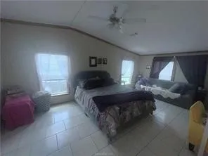 a bedroom with a bed couch and window