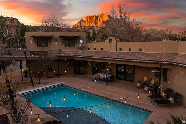 98 Bridge Road Rockville, UT 84763 - Photo 48 of 75 Back of house at dusk with a patio area, a tile roof, an outdoor pool, and stucco siding
