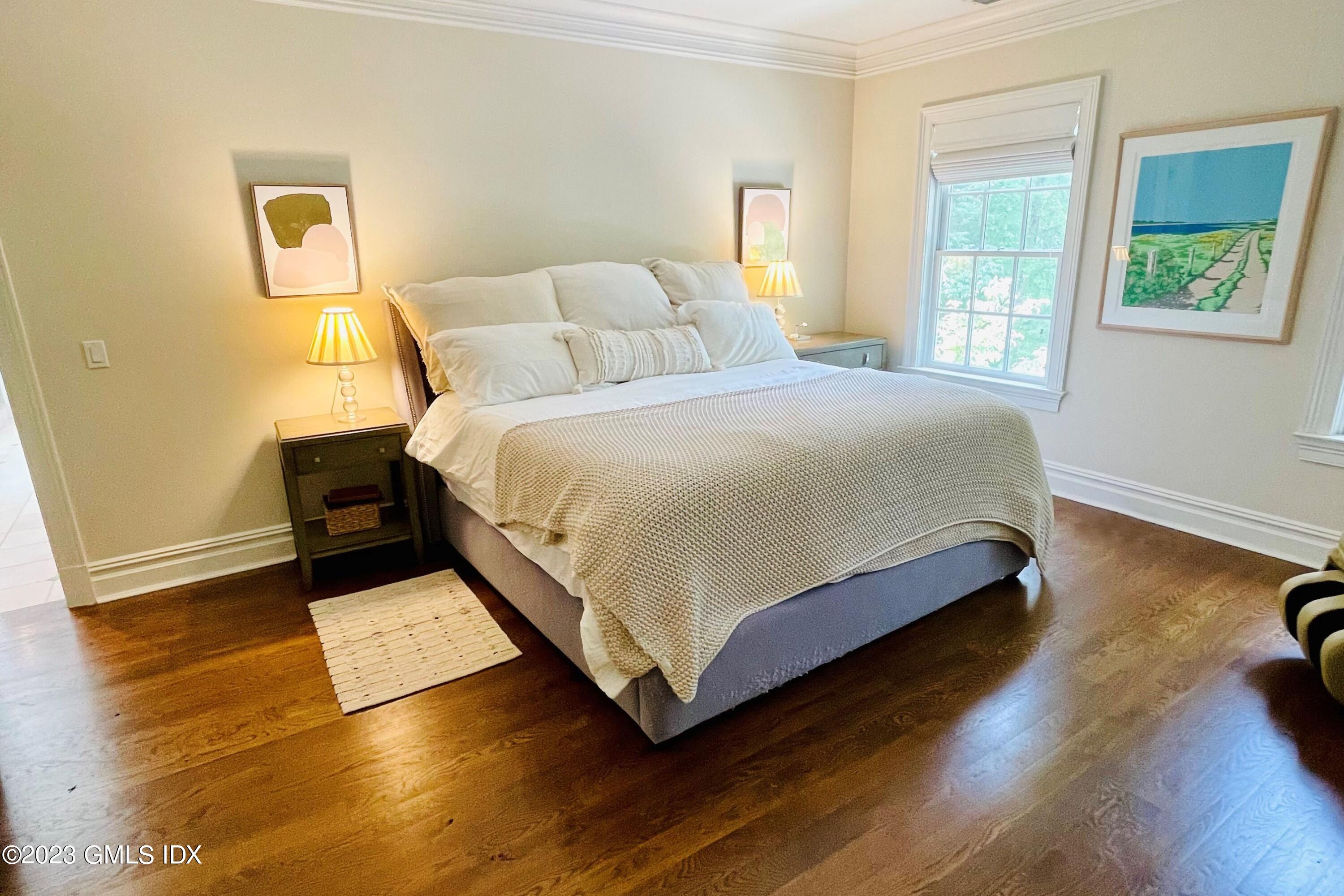 375 Stanwich Road Greenwich, CT 06830 - Photo 15 of 31 a bedroom with a bed and wooden floor