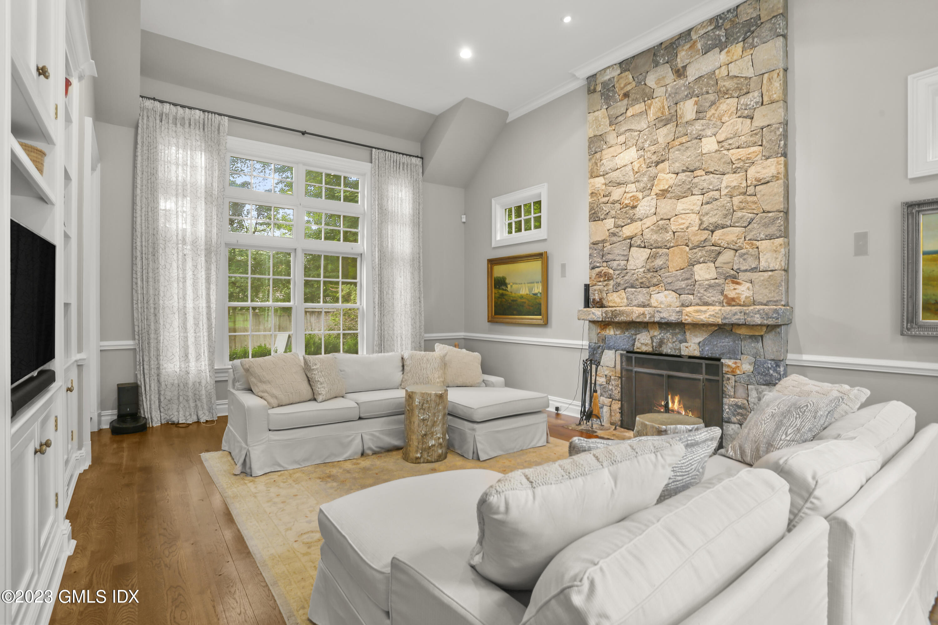 375 Stanwich Road Greenwich, CT 06830 - Photo 10 of 31 a living room with furniture a fireplace and a flat screen tv