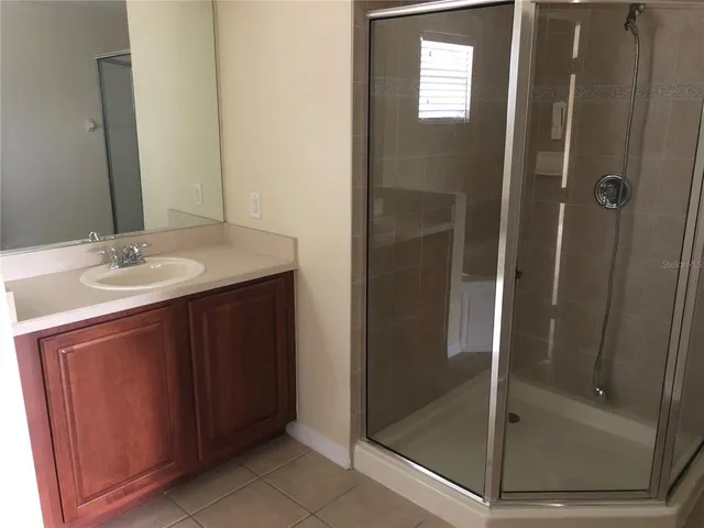 a bathroom with a shower sink and mirror