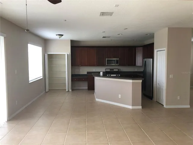a kitchen with stainless steel appliances granite countertop a stove a sink and a refrigerator