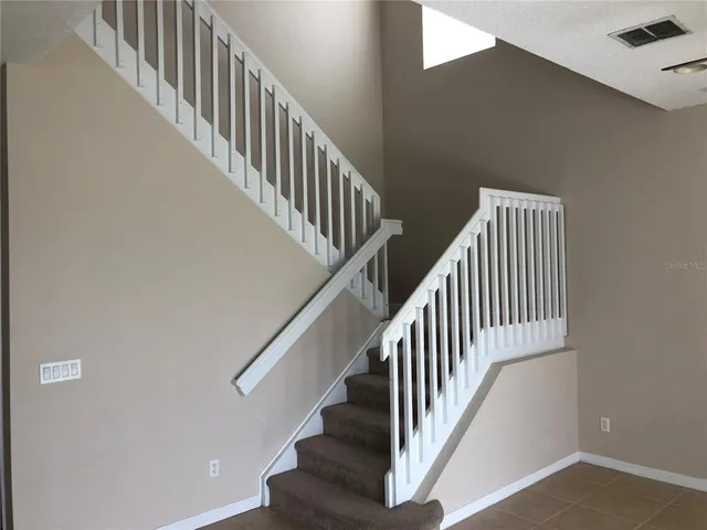 a view of staircase with wooden floor and white walls