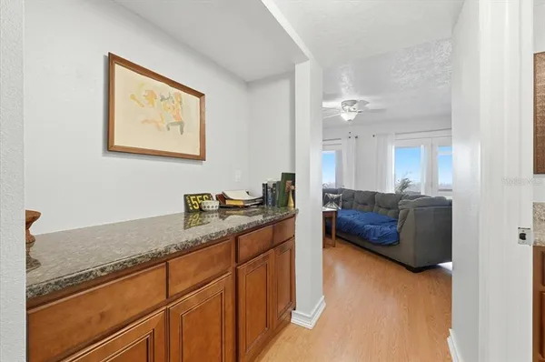 a view of kitchen with granite countertop cabinets and refrigerator