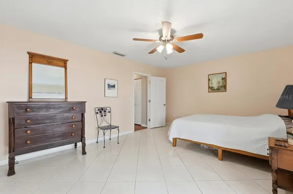 a spacious bedroom with a bed and a mirror