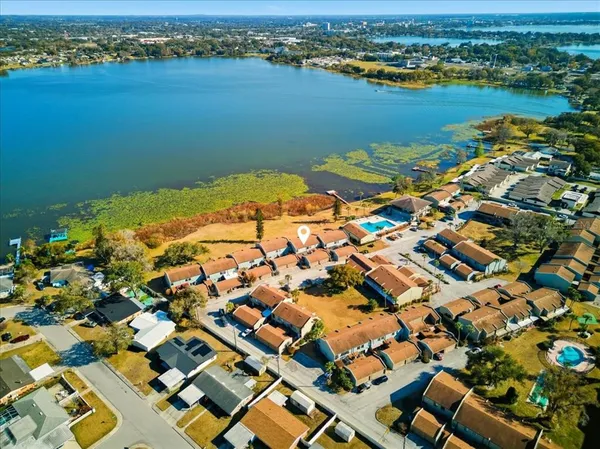 an aerial view of ocean and residential houses with outdoor space
