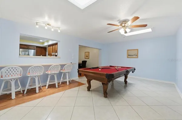 a room with pool table and windows