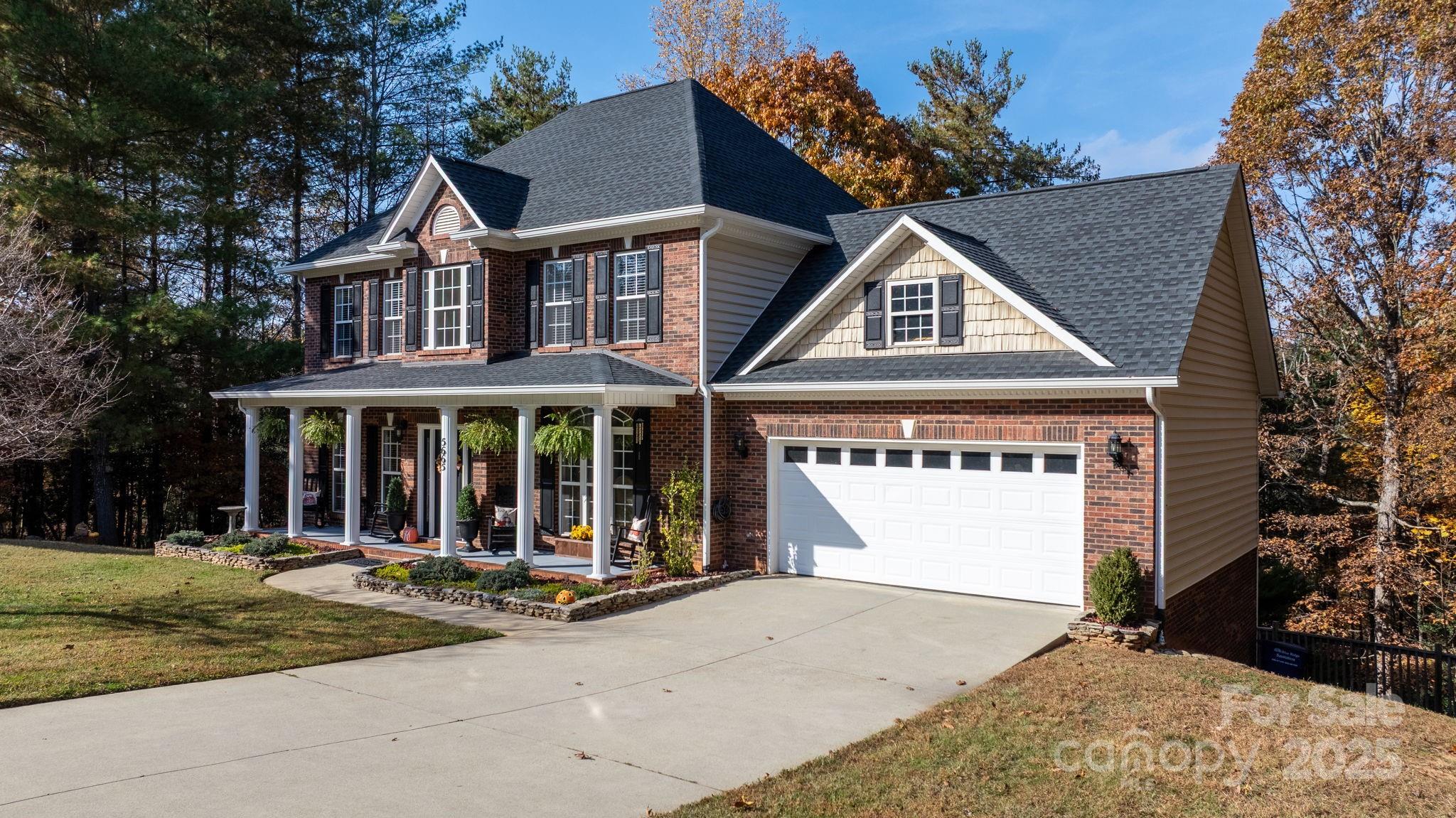 a view of a white house with large windows and a small yard
