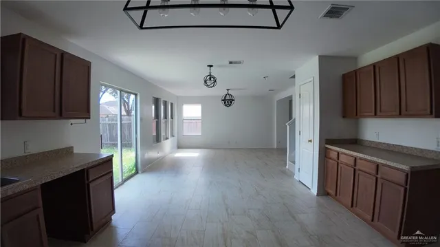 a view of a kitchen with an empty space and a window