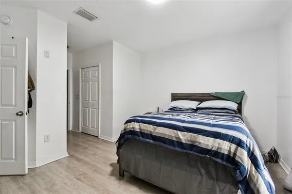 a bedroom with a bed and wooden floor