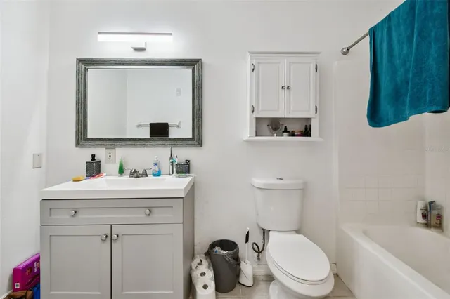 a bathroom with a toilet a sink a tub and mirror