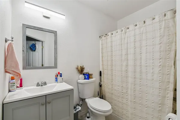 a bathroom with a sink a toilet and a mirror