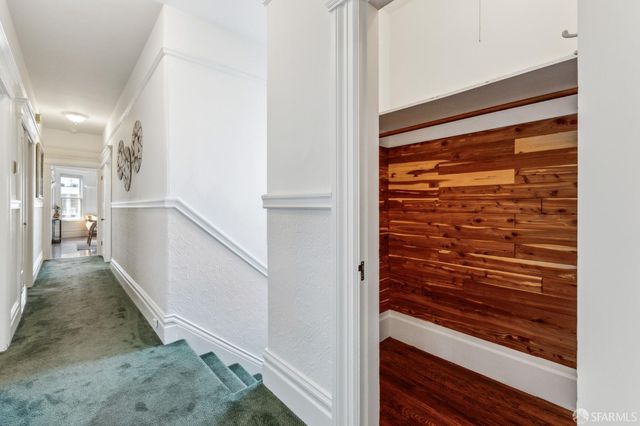 a view of a hallway with wooden floor and staircase