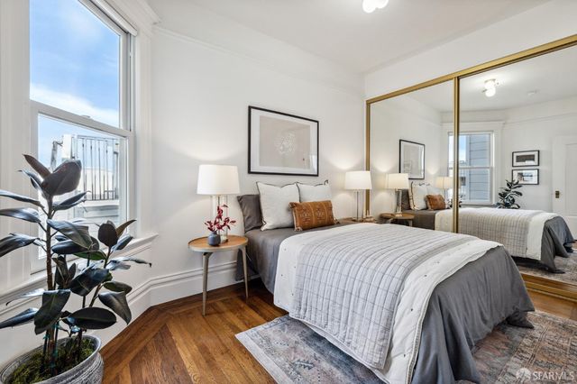 a bedroom with bed a lamp and potted plant
