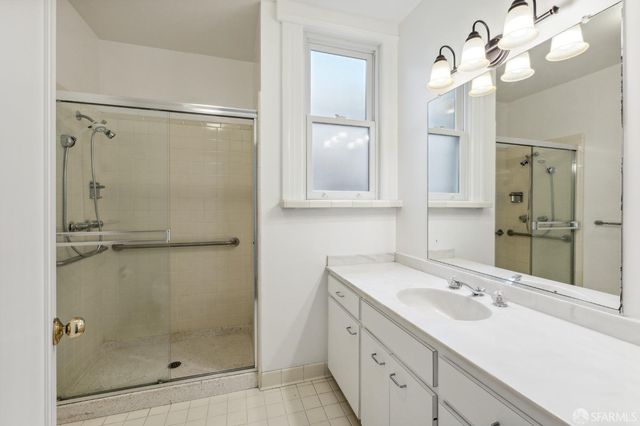 an empty room with wooden floor fireplace and windows