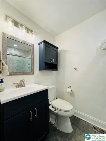 a bathroom with a toilet sink a mirror and vanity