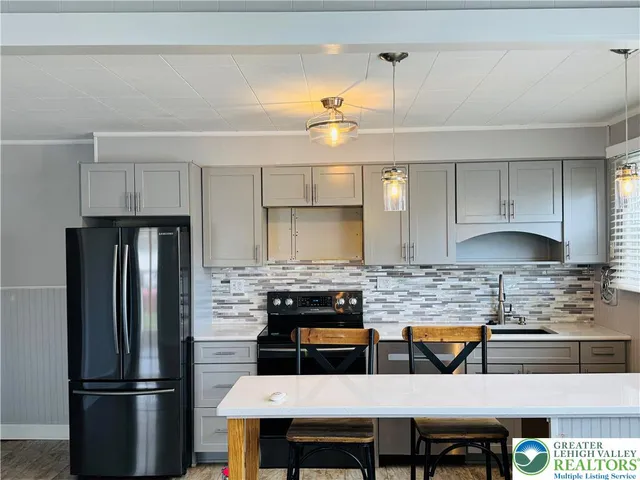 a kitchen with stainless steel appliances granite countertop a refrigerator a stove a sink and a refrigerator