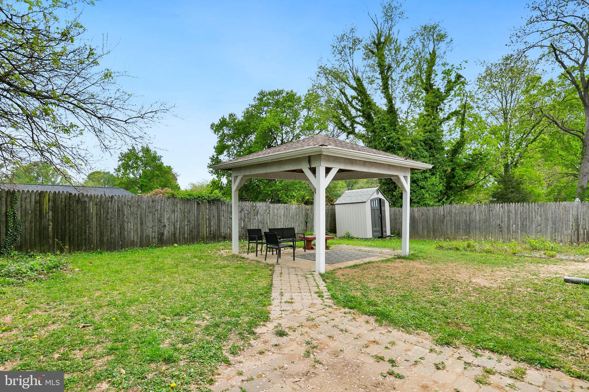 2920 Weisman Road Silver Spring, MD 20902 - Photo 31 of 32 a view of a backyard with table and chairs under an umbrella with large trees