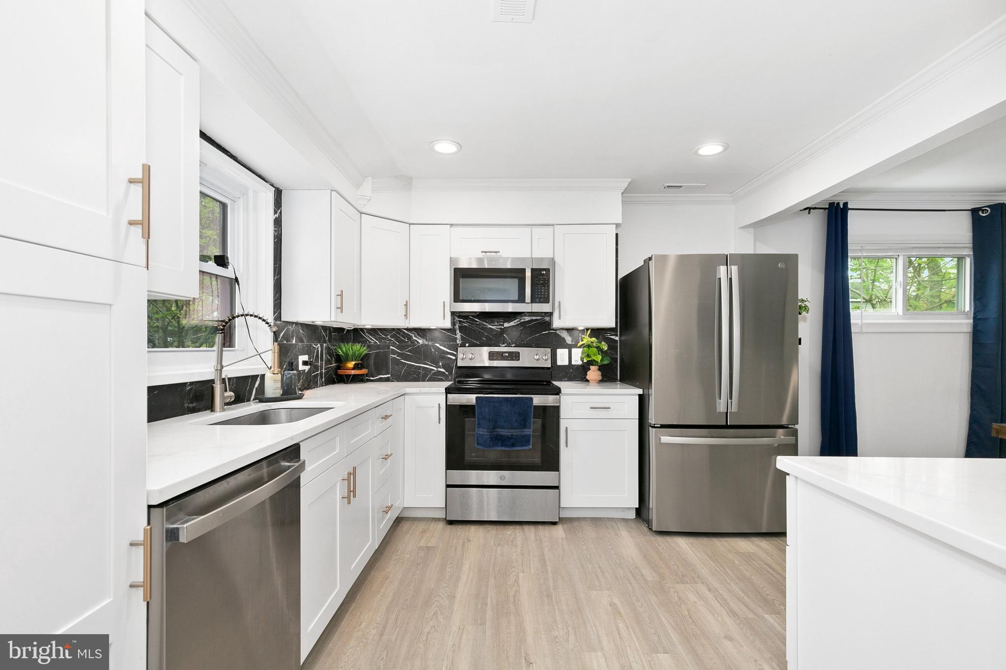 2920 Weisman Road Silver Spring, MD 20902 - Photo 5 of 32 a kitchen with a sink a refrigerator a microwave and cabinets