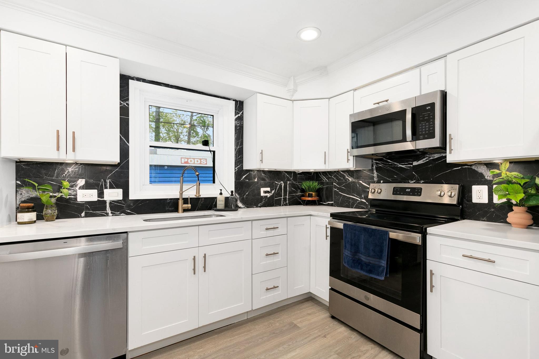 2920 Weisman Road Silver Spring, MD 20902 - Photo 7 of 32 a kitchen with stainless steel appliances granite countertop white cabinets sink and stove