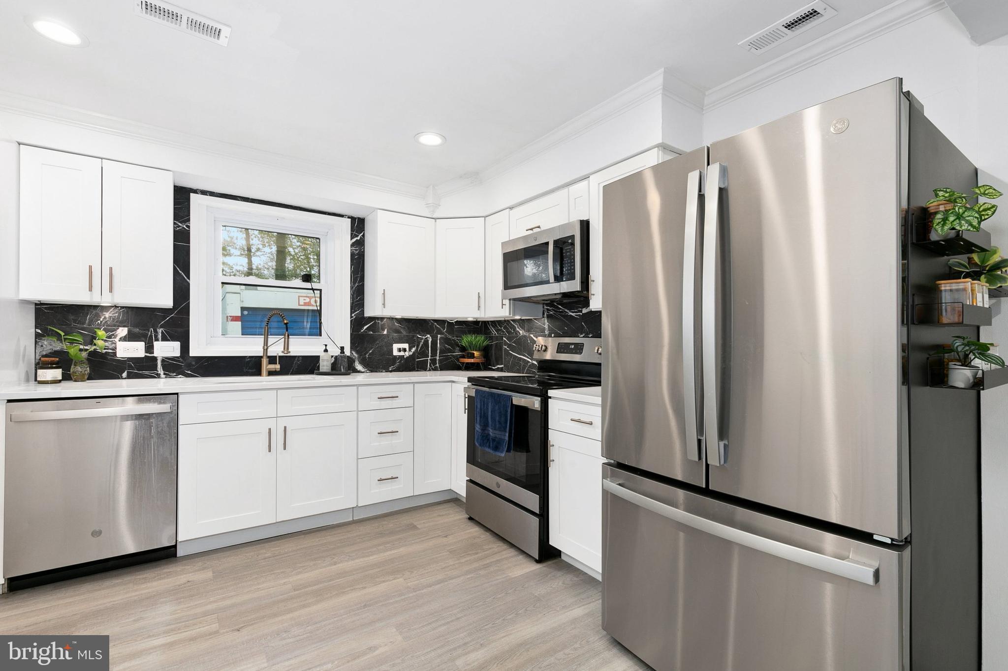 2920 Weisman Road Silver Spring, MD 20902 - Photo 9 of 32 a kitchen with stainless steel appliances a refrigerator sink and microwave