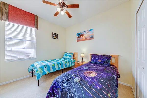 a bedroom with two beds and a lamp