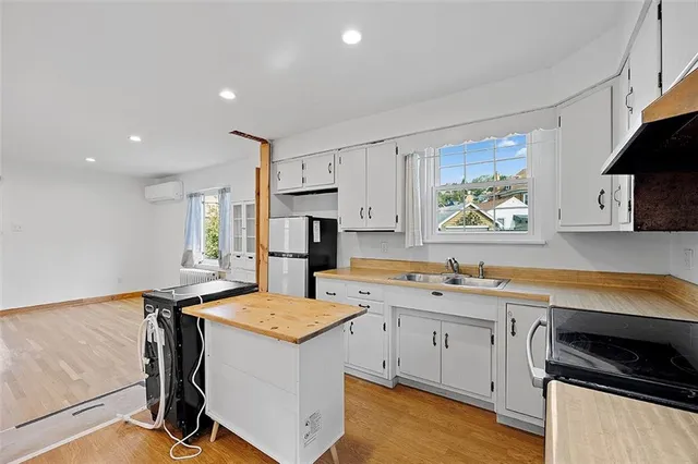 a kitchen with a stove a sink a microwave a counter space and cabinets