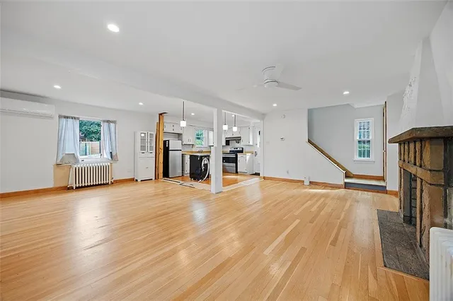 a view of empty room with wooden floor and stairs