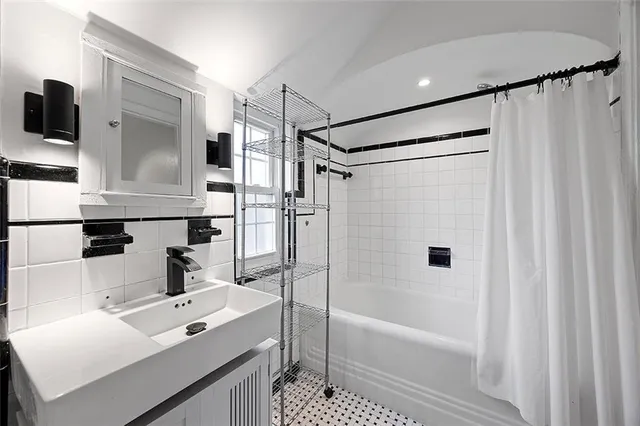 a bathroom with a tub a sink and a shower