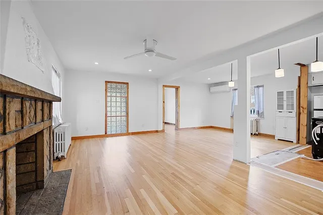 a view of a livingroom with wooden floor and a kitchen space
