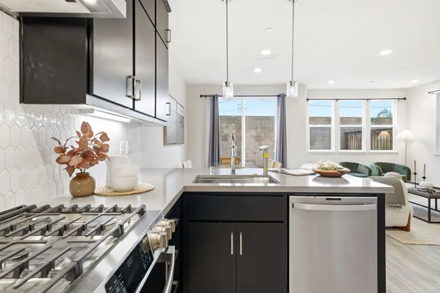 a kitchen with stainless steel appliances kitchen island a sink refrigerator and microwave