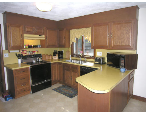 419 Border Road Concord, MA 01742 - Photo 5 of 13 a kitchen with a sink a stove top oven and a refrigerator
