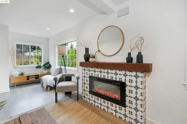 a living room with furniture a rug a fireplace and a large window