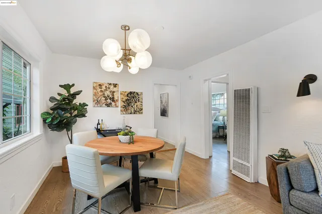 a dining room with furniture potted plants and wooden floor