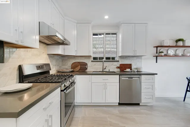 a kitchen with stainless steel appliances granite countertop a sink stove and cabinets